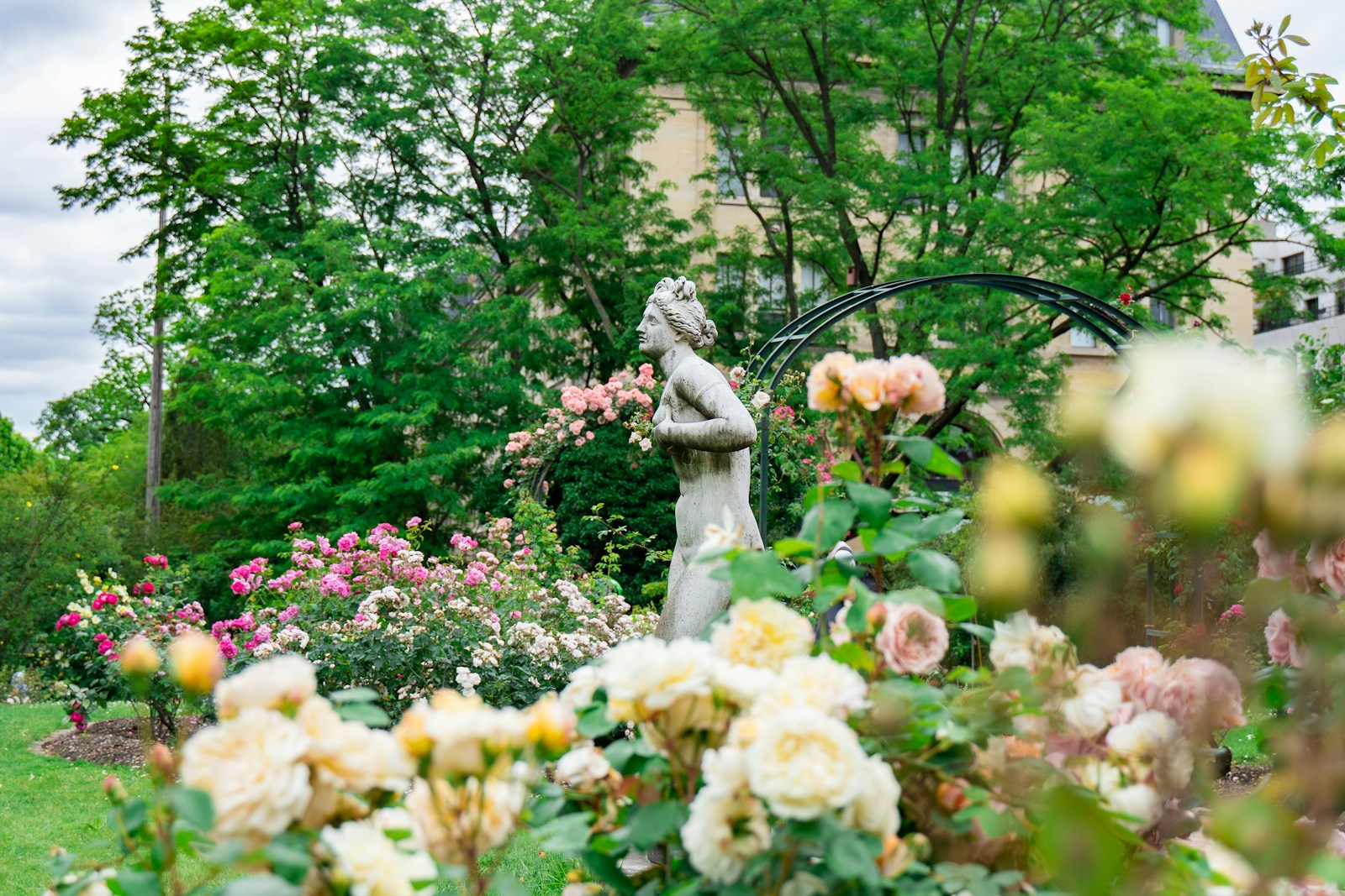 statue de femme près des plantes et des arbres du jardin d'un passionné