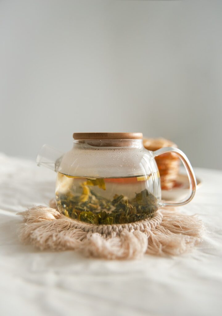 bocal en verre transparent sur textile blanc contenant du thé darjeeling