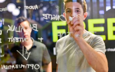 homme écrivant sur un tableau en verre la stratégie du référencement naturel de son entreprise