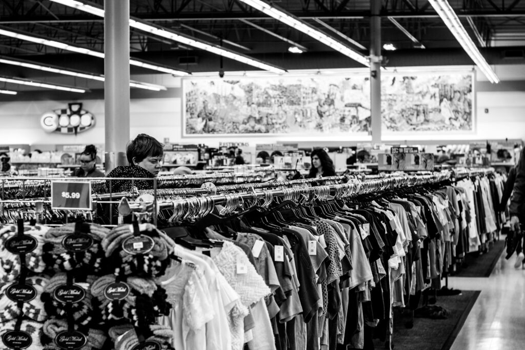 photographie en niveaux de gris de personnes à l'intérieur d'un magasin de vêtements