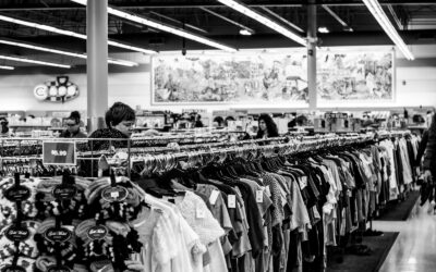 photographie en niveaux de gris de personnes à l'intérieur d'un magasin de vêtements