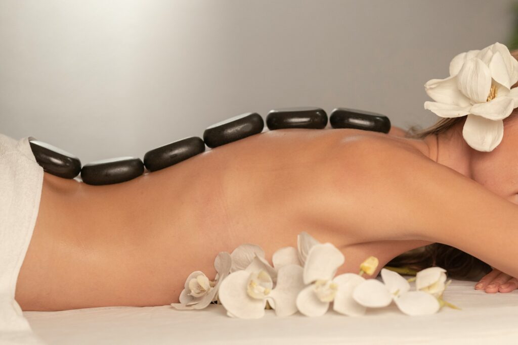 femme qui participe à une séance de bien-ètre avec un massage aux pierres chaudes