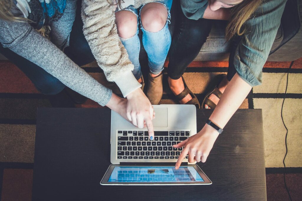 Trois personnes réunies autour d'un laptop pour échanger