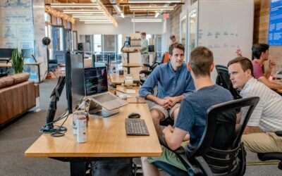 three men sitting on chair beside tables